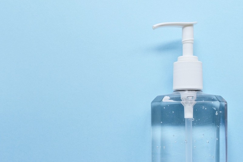 Bottle of a hand sanitizer against blue background hand sanitizer tile / Getty Images
