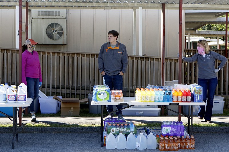 Staff photo by C.B. Schmelter / Chattanooga School for the Liberal Arts parent volunteer coordinator Jennifer Parris, left, District 8 School Board member Tucker McClendon, center, and CSLA Principal Krystal Scarbrough wait to distribute supplies at CSLA on Wednesday, April 15, 2020 in Chattanooga, Tenn. The school has been set up as a drop off and pick up point for supplies needed by those affected in Sunday's tornado.