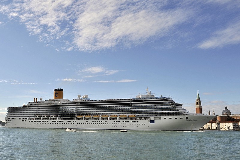 In this photo taken on Sunday, May 24, 2015, the Costa Deliziosa cruise ship sails past St. Mark's Square, visible in background at right, in Venice, Italy. Passengers on a luxury liner's around-the-world cruise, which began before the globe was gripped by the coronavirus pandemic, are finally approaching their odyssey's end after 15 weeks at sea. Next week, the Costa Deliziosa is due to reach Spain and Italy, two of the countries most devastated by COVID-19 infections. (AP Photo/Luigi Costantini)