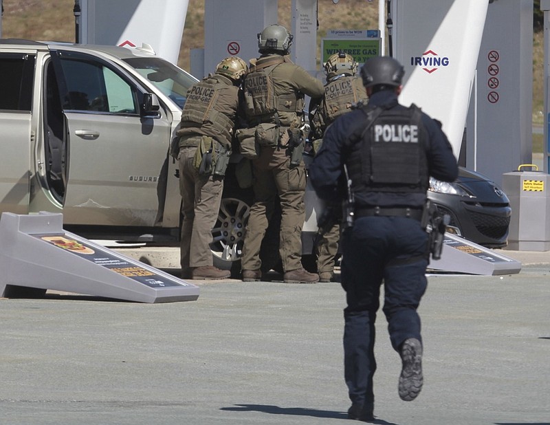 Royal Canadian Mounted Police officers prepare to take a person into custody at a gas station in Enfield, Nova Scotia on Sunday April 19, 2020. A suspect in an active shooter investigation is in custody in Nova Scotia, with police saying several people were harmed before a man wearing police clothing was arrested. Gabriel Wortman was arrested by the RCMP at the Irving Big Stop in Enfield, N.S., about 35 km from downtown Halifax. (Tim Krochak/The Canadian Press via AP)