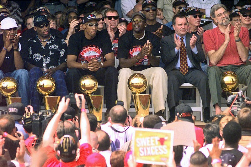 FILE - In this June 16, 1998, file photo, NBA Champions, from left: Ron Harper, Dennis Rodman, Scottie Pippen, Michael Jordan and coach Phil Jackson are joined on stage by Chicago Mayor Richard Daley, second from right, during a city-wide rally in Chicago to celebrate the Chicago Bulls 6th NBA championship. Jordan described his final NBA championship season with the Chicago Bulls as a "trying year." "We were all trying to enjoy that year knowing it was coming to an end," Jordan told Good Morning America on Thursday, April 16, 2020. (AP Photo/Beth A. Keiser, File)