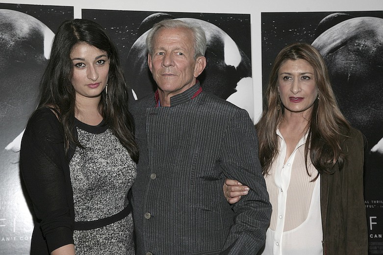 This June 20, 2013 file photo shows, photographer Peter Beard, flanked by Zara Beard, left, and Nejma Khanum at a screening of "Blackfish" in New York. Beard has been found dead three weeks after being reported missing from his cliff-side home at the tip of Long Island. He was 82. His family posted a statement on Beard's website Sunday night saying "He died where he lived: in nature." Beard was best known for his photos of African wildlife, taken in the decades when he lived and worked at his tent camp in Kenya. (Photo by Andy Kropa/Invision/AP, File)