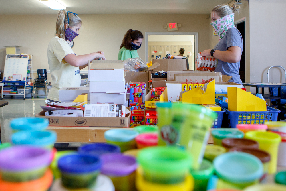 Staff photo by C.B. Schmelter / Sisters Mollie, left, and Allie Bishop, right, help organize items to be put into care packages in the auditorium at Chattanooga School for the Liberal Arts on Monday, April 20, 2020 in Chattanooga, Tenn. Teachers and volunteers made care packages for 250 East Brainerd Elementary students who were displaced by Easter Sunday's tornado. The packages included school materials but also items like Play-Doh, colored pencils and books.