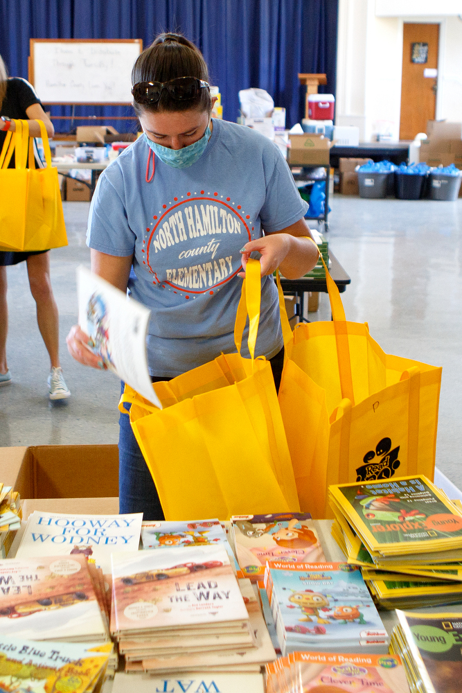 Staff photo by C.B. Schmelter / North Hamilton County Elementary School music teacher Julia Mayo puts a book into a care package in the auditorium at Chattanooga School for the Liberal Arts on Monday, April 20, 2020 in Chattanooga, Tenn. Teachers and volunteers made care packages for 250 East Brainerd Elementary students who were displaced by Easter Sunday's tornado. The packages included school materials but also items like Play-Doh, colored pencils and books.