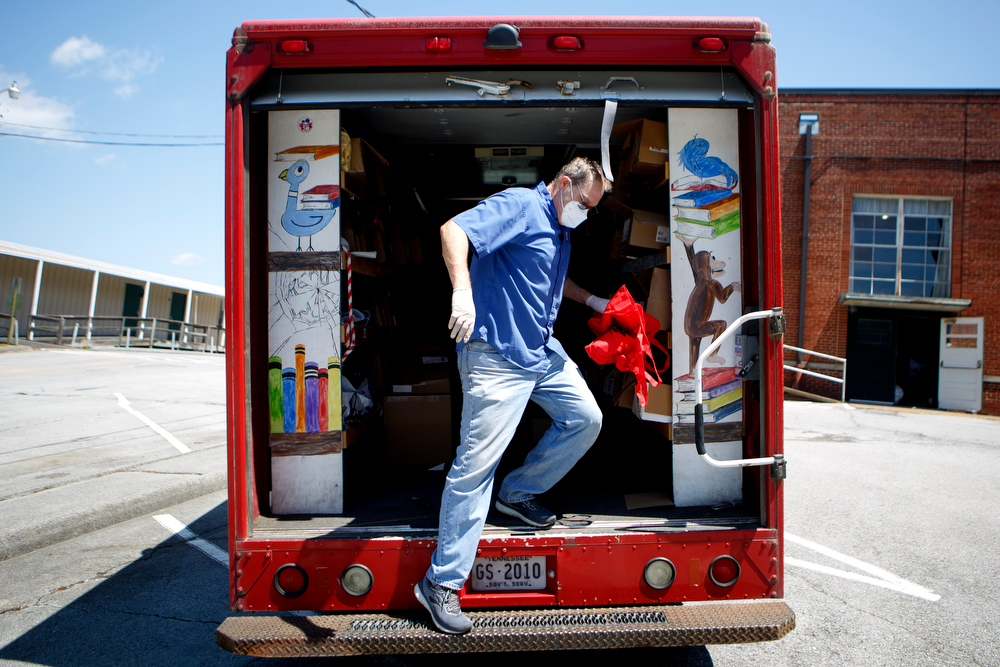 Staff photo by C.B. Schmelter / Stewart Payne, with Read 20, gets some bags from the Readmobile at Chattanooga School for the Liberal Arts on Monday, April 20, 2020 in Chattanooga, Tenn. Teachers and volunteers made care packages for 250 East Brainerd Elementary students who were displaced by Easter Sunday's tornado. The packages included school materials but also items like Play-Doh, colored pencils and books.