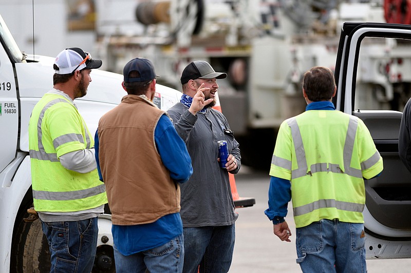 Staff Photo by Robin Rudd / Crews talk in the Hamilton Place Mall parking lot before heading out.  In the wake of the EF3 Tornado on Easter Sunday night the parking lot at Hamilton Place Mall has become a staging area for the personal and equipment engaged in restoring services to the effected areas.  The site was photographed on April 21, 2020.  