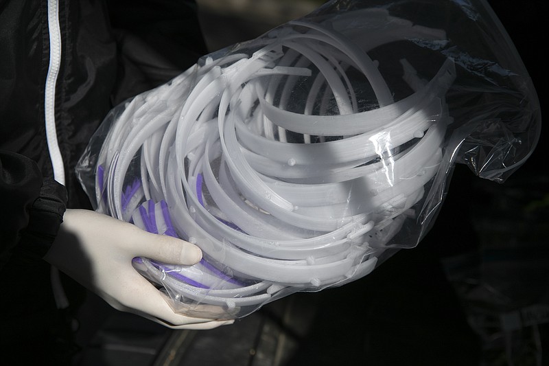 High school junior, Will Olsen, 17, of Kensington, Md., holds a bag of pieces for medical face shields that were printed using personal 3D printers, in Kensington, Md., Sunday, April 19, 2020. The pieces are delivered to the Eaton Hotel in downtown Washington for assembly. (AP Photo/Jacquelyn Martin)


