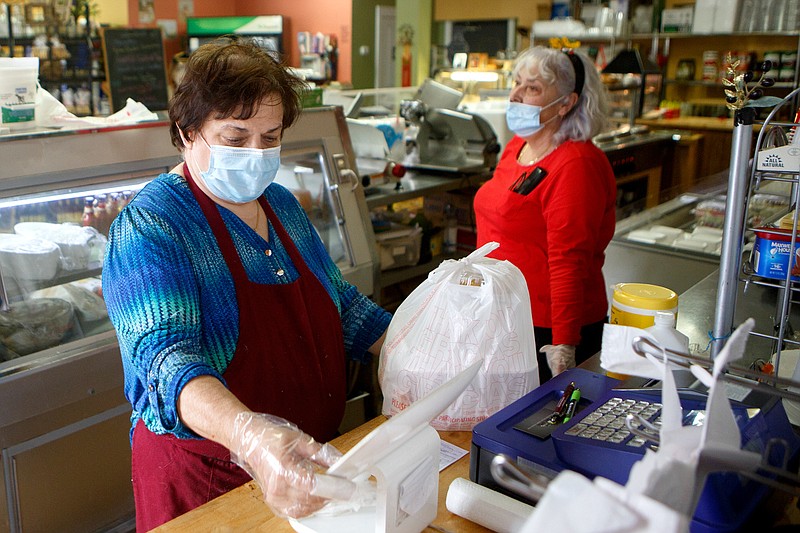 Staff photo by C.B. Schmelter / Owner Callie Meta, left, rings up a to-go order at Olive Branch on Thursday, April 23, 2020 in Chattanooga, Tenn. Itճ been a little over a month since the Hamilton County Health Department issued a statement noting that it would suspend its routine inspections of area restaurants during the COVID-19 pandemic, and Environmental Health Director Bonnie Deakins said her department has had only a couple of complaints from patrons alleging that some restaurants were not following some recommended policies regarding how to safety get food to people.