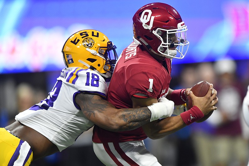 AP photo by John Amis / Oklahoma quarterback Jalen Hurts is sacked by LSU linebacker K'Lavon Chaisson during the first half of the Peach Bowl national semifinal on Dec. 28, 2019, at Mercedes-Benz Stadium in Atlanta.