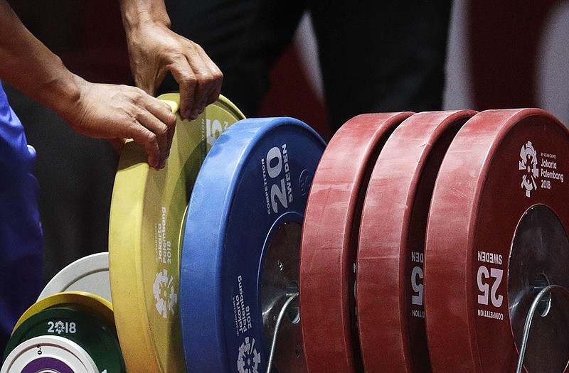 AP file photo by Aaron Favila / Olympic weights tile