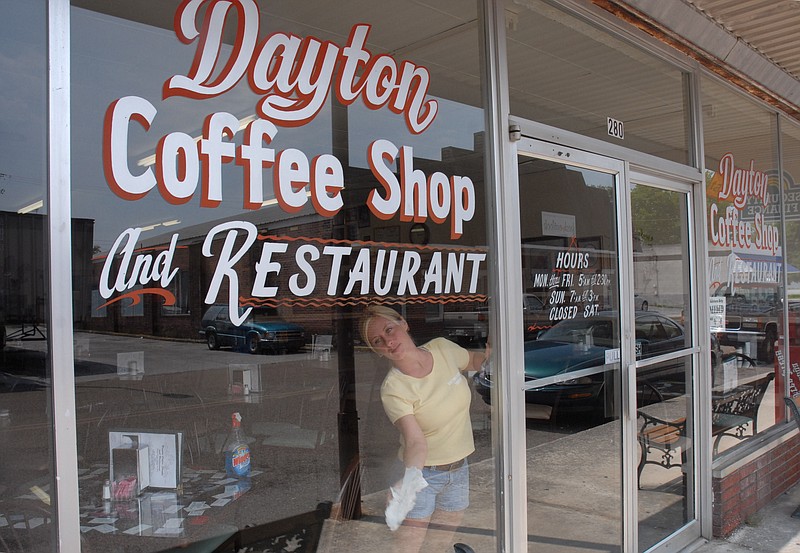 Staff Photo by Tim Barber / Lorie Taylor cleans the windows after business hours on Tuesday at the Dayton Coffee Shop and Restaurant on East Second Street in Dayton, Tenn.