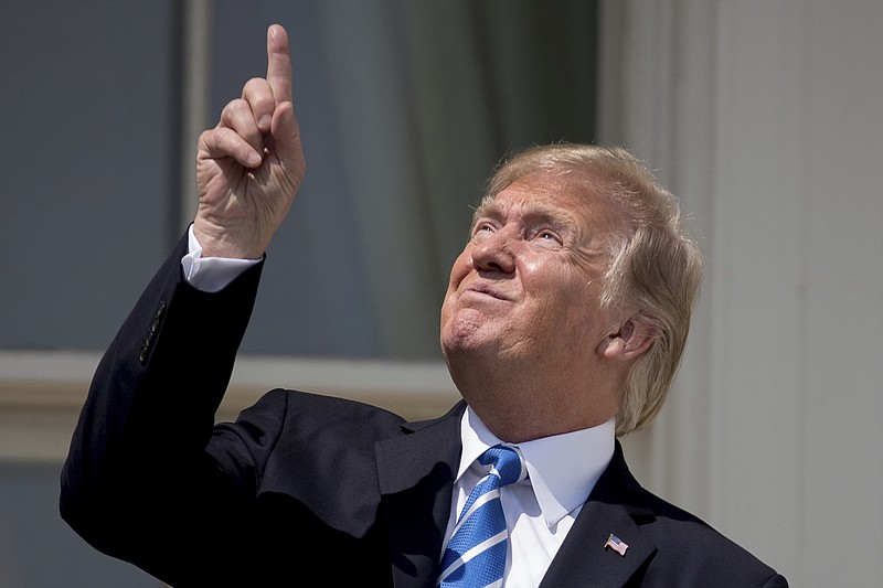 Photo by Andrew Harnik of The Associated Press / In this Aug. 21, 2017, file photo, President Donald Trump points to the sun as he arrives to view the solar eclipse at the White House in Washington. Trump's comment about injecting disinfectant to fight coronavirus is just the latest comments that run contrary to mainstream science.