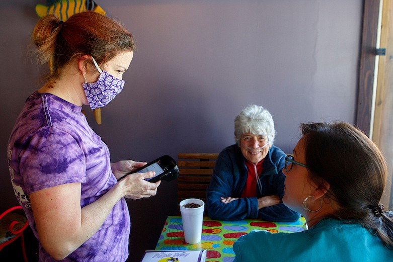 Staff photo by C.B. Schmelter / Ashley Davis, left, takes Daisy Blangon, center, and Amanda Barton's orders at Purple Daisy Picnic Cafe on Monday, April 27, 2020 in Chattanooga, Tenn. Blangon, who is a regular, said she was excited to eat inside the restaurant again. Restaurants around Chattanooga began to reopen following the shutdown due to the coronavirus.