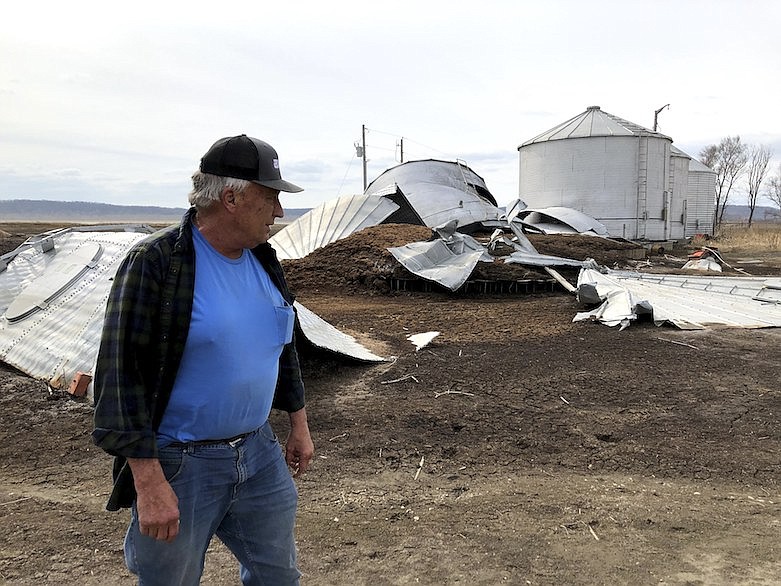 This photo taken March 12, 2020, near Rock Port, Missouri, shows tenant farmer Phil Graves examining grain storage bins that were destroyed in a 2019 flood. Some of the land where Graves grows corn has been offered for sale to provide room for a levee to be rerouted so the Missouri River can roam more widely. Levee setbacks are among measures being taken in the U.S. heartland to control floods in ways that work with nature instead of trying to dominate it with concrete infrastructure. Graves says he'd prefer to keep cultivating the parcel but understands why the setback is needed. (AP Photo/John Flesher)