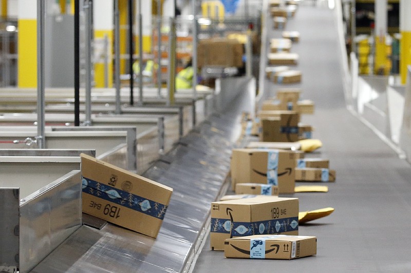 FILE - In this Dec. 17, 2019, file photo, Amazon packages move along a conveyor at an Amazon warehouse facility in Goodyear, Ariz. Amazon will report quarterly earnings on Thursday, APril 30, 2020, providing a first glimpse into its financial performance during the pandemic. (AP Photo/Ross D. Franklin, File)