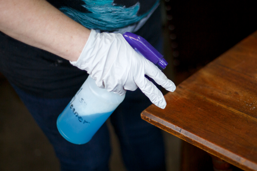 Staff photo by C.B. Schmelter / Owner Carol Ellis cleans off a table at The Refindery on Wednesday, April 29, 2020 in Chattanooga, Tenn. Following the shutdown due to the coronavirus pandemic, the store is preparing to reopen on Friday, May 1.