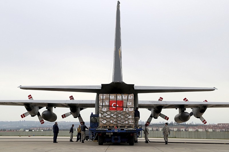 In this handout photo provided by the Turkish Defense Ministry, Turkish soldiers load a Turkish military cargo plane with Personal Protection Equipment donated by Turkey to help United States combat the new coronavirus outbreak, at the Etimesgut airport outside Ankara, Turkey, Thursday, April 30, 2020. Turkey is sending a second planeload of surgical masks, N95 masks and hazmat suits tor U.S. to help the country battle the coronavirus outbreak.(Turkish Defence Ministry via AP)