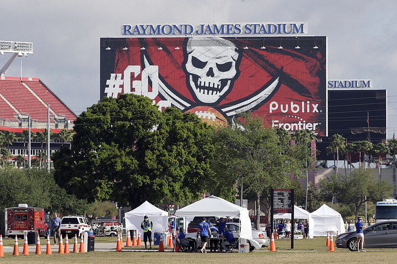 AP photo by Chris O'Meara /Medical personnel from BayCare test people for the coronavirus in the parking lot outside Raymond James Stadium, the home of the NFL's Tampa Bay Buccaneers, on March 25 in Tampa, Fla.