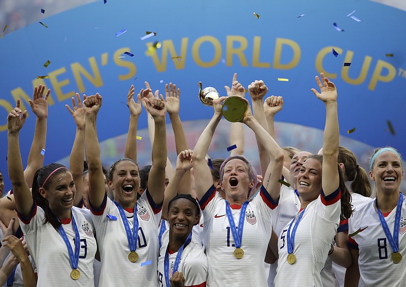 AP photo by Alessandra Tarantino / Megan Rapinoe, lifting trophy, and her U.S. soccer teammates celebrate after winning the Women's World Cup final against the Netherlands on July 7, 2019, at Stade de Lyon near Lyon, France.