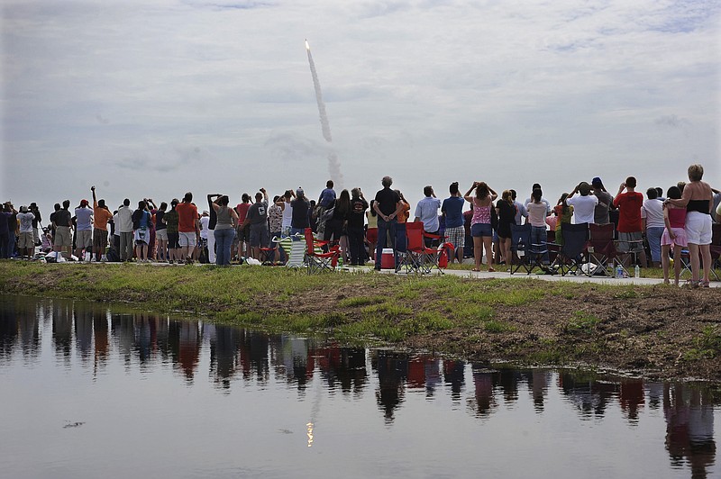 FILE - In this July 8, 2011 file photo, spectators watch the space shuttle Atlantis lift off from the Kennedy Space Center at Cape Canaveral, Fla. Atlantis was the 135th and final space shuttle launch for NASA. On Friday, May 1, 2020, NASA and SpaceX urged everyone to stay home for the first home launch of astronauts in nearly a decade, coming up later in the month, because of the coronavirus pandemic. (AP Photo/Phil Sandlin)



