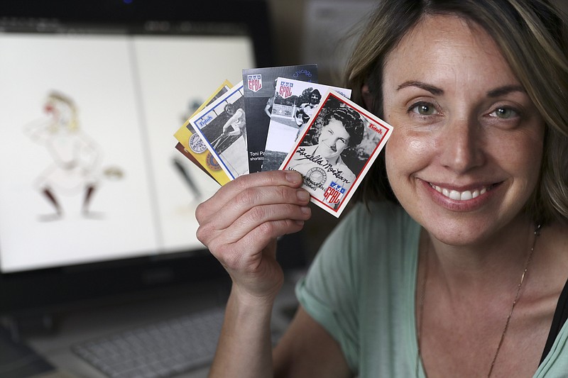 In this April 30, 2020, photo, Anika Orrock holds some of her autographed baseball cards of players from the All-American Girls Baseball League at her home in Nashville, Tenn. Orrock has written and illustrated a book on the players titled "The Incredible Women of the All-American Girls Professional Baseball League." (AP Photo/Mark Humphrey)


