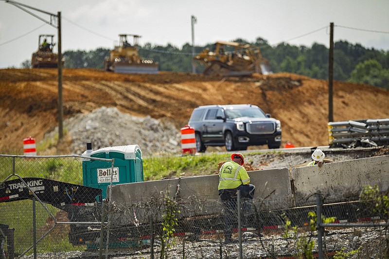 Staff photo by Troy Stolt / Construction workers secure concrete onto the back of a trailer at a construction site at the split between interstates 24 and 75 on Monday, May 4, 2020 in Chattanooga, Tenn.