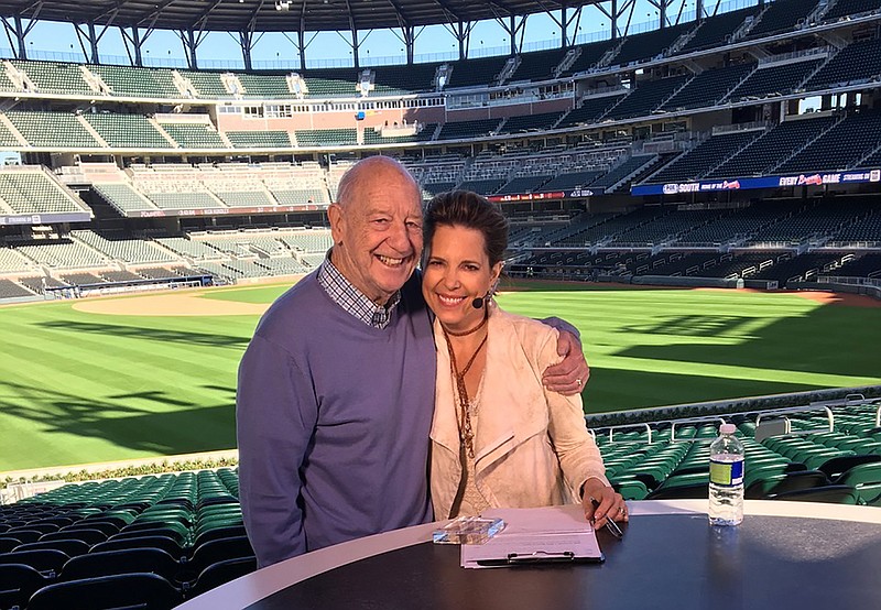 Hannah Storm photo via AP / Mike Storen poses with daughter Hannah Storm at the Atlanta Braves' stadium in March 2017.