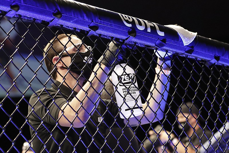 AP photo by John Raoux / A worker wipes down areas of the octagon between bouts at UFC 249 on Saturday night in Jacksonville, Fla.