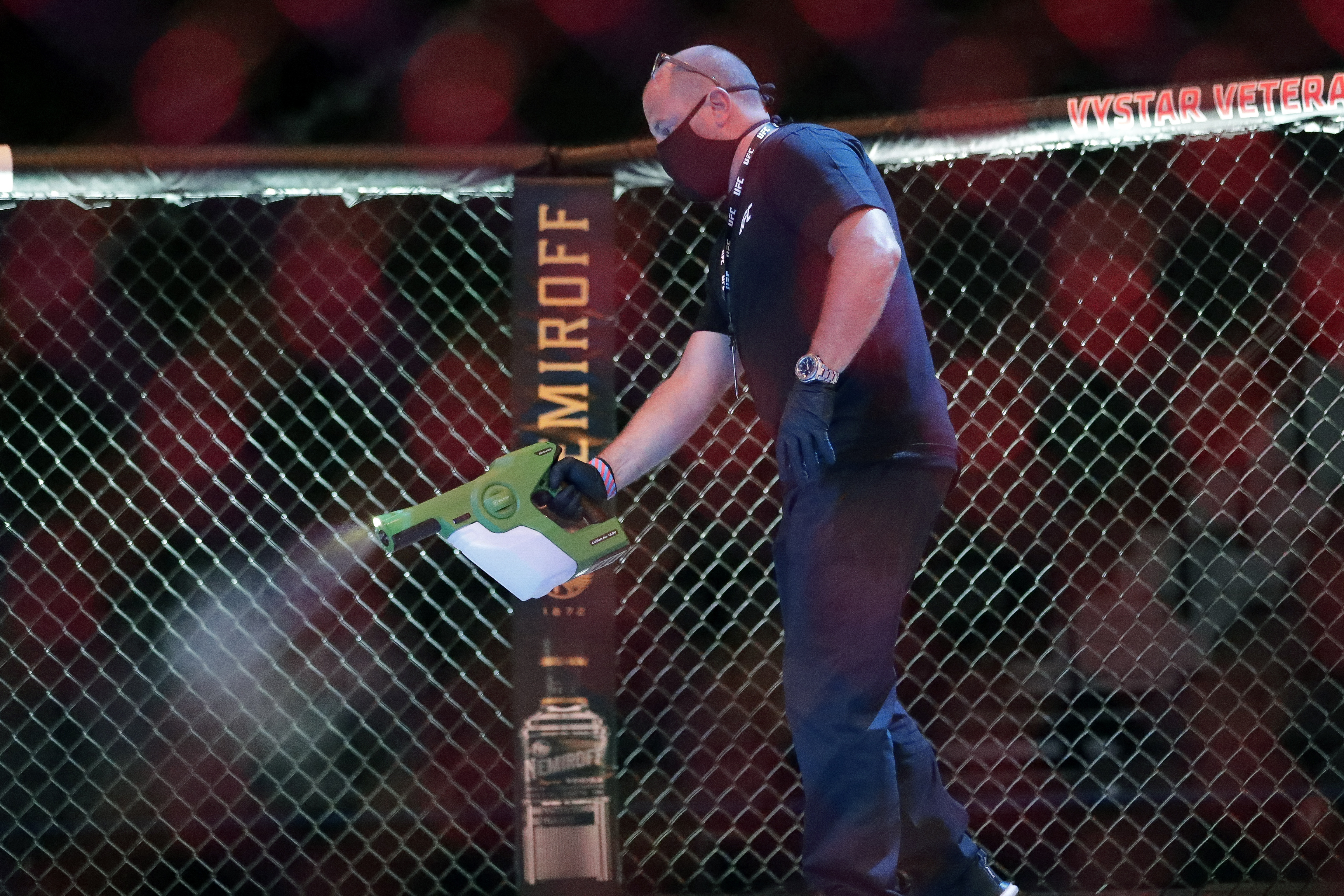 AP photo by John Raoux / A worker sprays sanitizer in the octagon between bouts at UFC 249 on Saturday night in Jacksonville, Fla.
