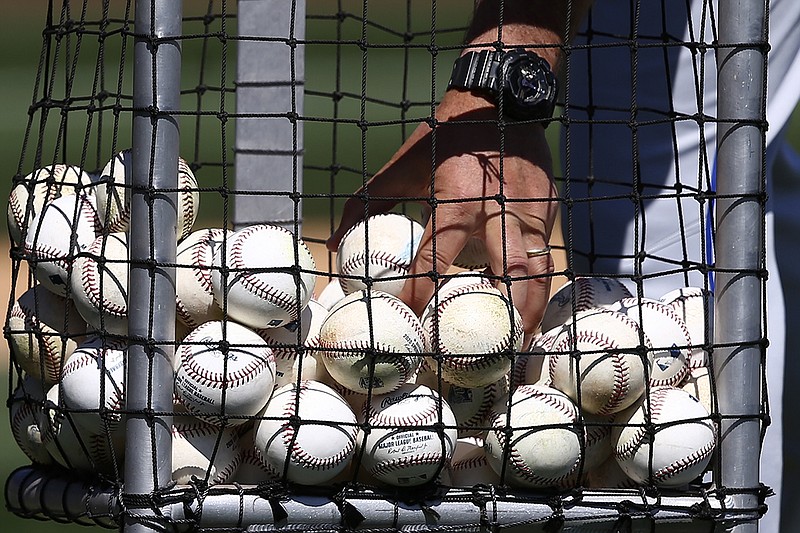 AP photo by Ross D. Franklin / Kansas City Royals hitting coach John Mabry reaches for a few baseballs as he throws batting practice prior to a spring training game against the Arizona Diamondbacks on March 9 in Scottsdale, Ariz.