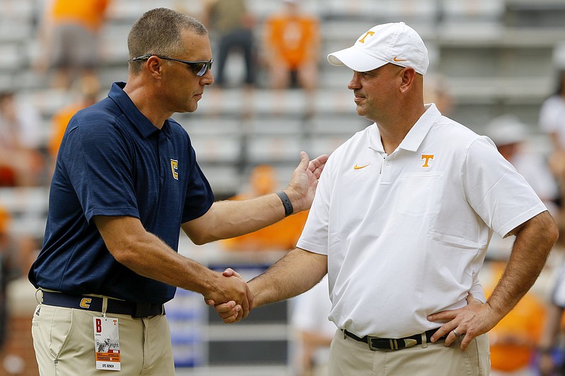 Staff file photo by C.B. Schmelter / UTC football coach Rusty Wright, left, shakes hands with Tennessee counterpart Jeremy Pruitt before their teams' 2019 game in Knoxville. 
