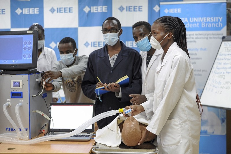 In this photo taken Monday, April 13, 2020, medical students test a self-designed computer-controlled ventilator prototype at the Chandaria Business and Incubation Centre of Kenyatta University in Nairobi, Kenya. Researchers across Africa are looking for ways to make their own ventilators, protective equipment and hand sanitizers as the continent faces a peak in coronavirus cases long after the United States and European countries have bought up global supplies during the pandemic. (AP Photo/John Muchucha)