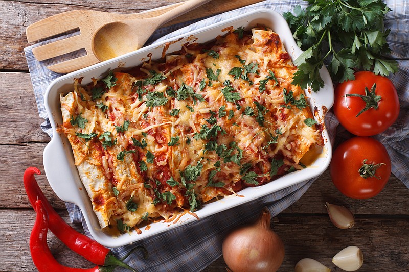 Mexican enchilada in a baking dish horizontal top view close-up - stock photo enchiladas / Getty Images
