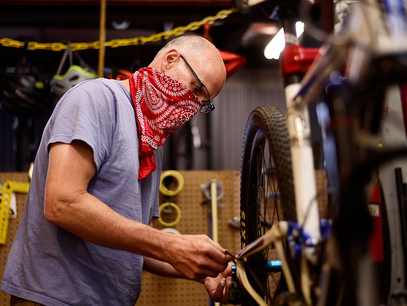 Staff Photo by Robin Rudd / Mike Skiles, owner of Suck Creek Cycle, overhauls a bicycle in his North Chattanooga shop on May 12, 2020. Cycling is seeing a boom during the COVID-19 pandemic.