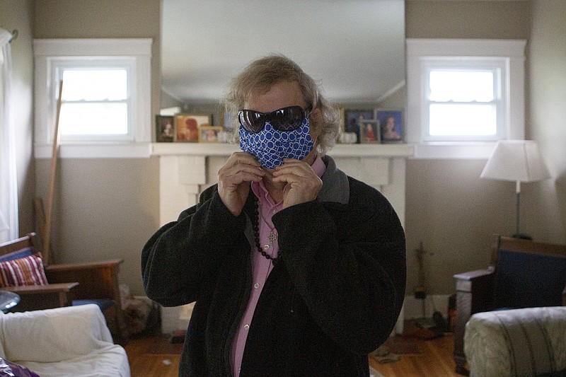 Staff file photo by C.B. Schmelter / Gary Shimel puts on a mask and glasses at his Brainerd home before getting on the CARTA Care-A-Van on Thursday, April 23, 2020. The CDC recommends that people wear a cloth face covering when going out in public regardless of whether they have symptoms.