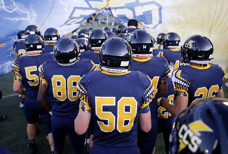 Staff photo by C.B. Schmelter / Chattanooga Christian School football players break through their spirit banner before a home game against Boyd Buchanan on Sept. 20, 2019. CCS has hired its first full-time strength and conditioning coach, and Tony Decker brings decades of collegiate experience to the job.