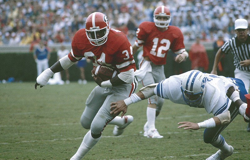 AP photo / Georgia Bulldogs running back Herschel Walker slips past a BYU defender on Sept. 11, 1982, in Athens, Ga. Georgia won 17-14 to improve to 2-0 on the way to a 11-0 regular season.