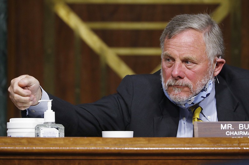 Chairman Richard Burr, R-N.C., reaches for hand sanitizer at a Senate Intelligence Committee nomination hearing for Rep. John Ratcliffe, R-Texas, on Capitol Hill in Washington, Tuesday, May. 5, 2020. The panel is considering Ratcliffe's nomination for director of national intelligence. (AP Photo/Andrew Harnik, Pool)