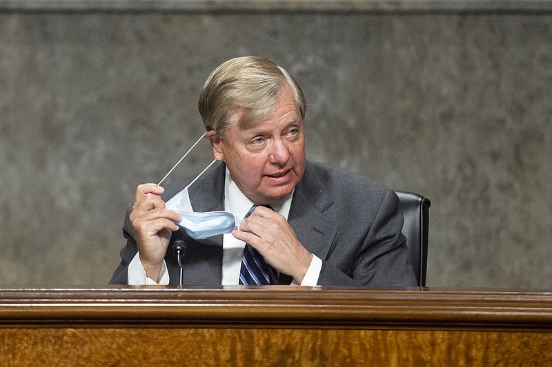 Chairman Lindsey Graham, R-S.C., takes off his mask as he arrives for the Senate Judiciary Committee hearing on "Examining Liability During the COVID-19 Pandemic" on Capitol Hill in Washington on Tuesday, May 12, 2020. (Caroline Brehman/CQ Roll Call/Pool via AP)


