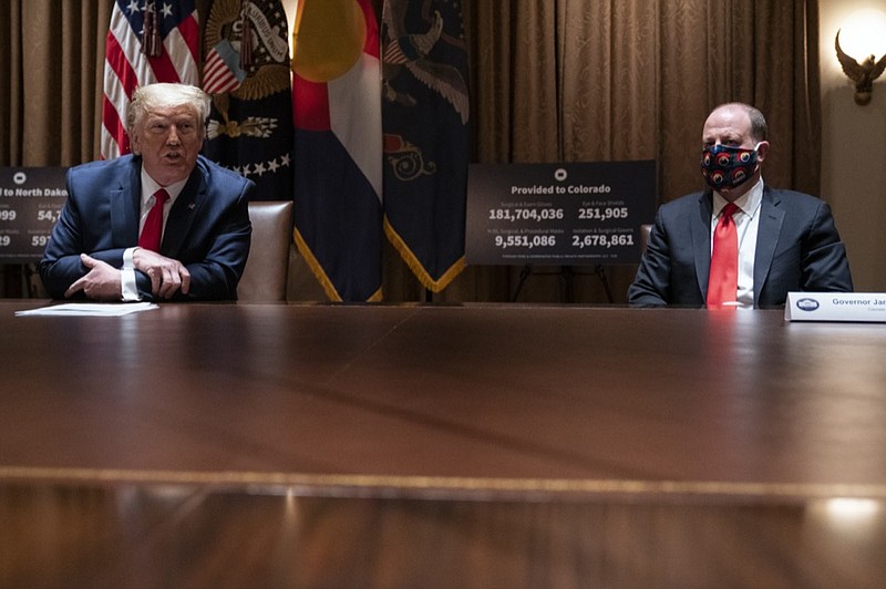 President Donald Trump speaks during a meeting with Colorado Gov. Jared Polis, right, on the coronavirus response, in the Cabinet Room of the White House, Wednesday, May 13, 2020, in Washington. (AP Photo/Evan Vucci)


