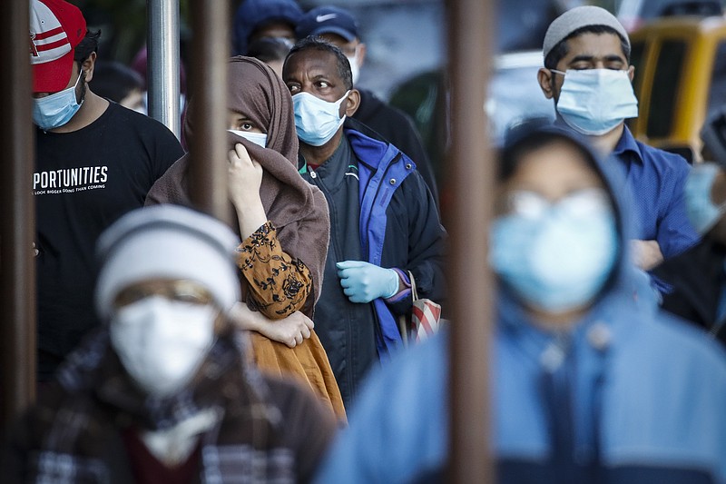 People wearing masks wait in line for food donations Wednesday, May 13, 2020, in the Brooklyn borough of New York, during the coronavirus pandemic. (AP Photo/John Minchillo)



