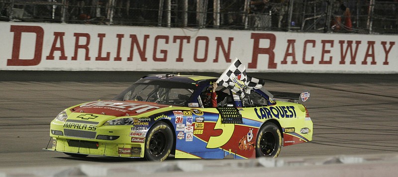 AP photo by Brett Flashnick / NASCAR Cup Series driver Mark Martin waves the checkered flag after winning the Southern 500 on May 9, 2009, at Darlington Raceway in South Carolina.