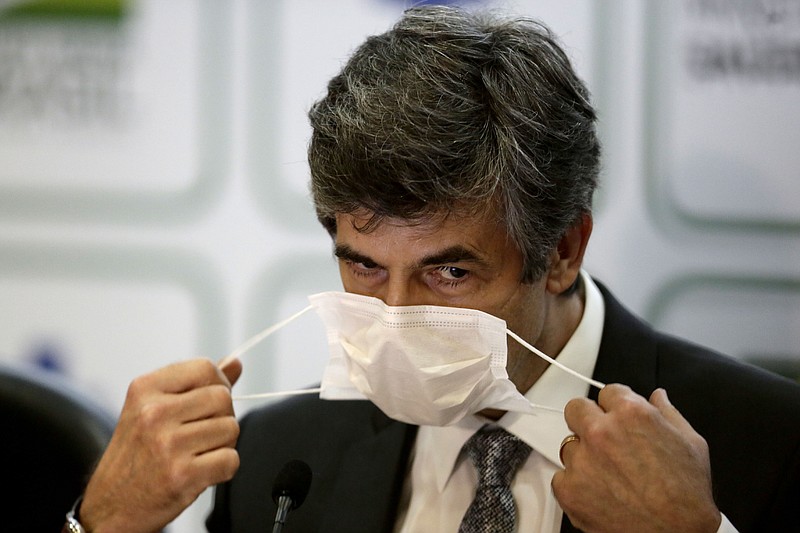 Brazil's outgoing Health Minister Nelson Teich removes his mask to give a news conference at the Health Ministry in Brasilia, Brazil, Friday, May 15, 2020. Teich resigned on Friday after less than a month on the job in a sign of continuing upheaval in the nation's battle with the COVID-19 pandemic and President Jair Bolsonaro's pressure for the nation to prioritize the economy over health-driven lockdowns. (AP Photo/Eraldo Peres)
