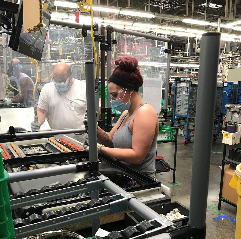 Roper employee Victoria Morgan is working behind a Lexan plastic barrier at the plant. She is also wearing a mask, safety glasses and gloves to perform her job. / Contributed photo from Roper 

