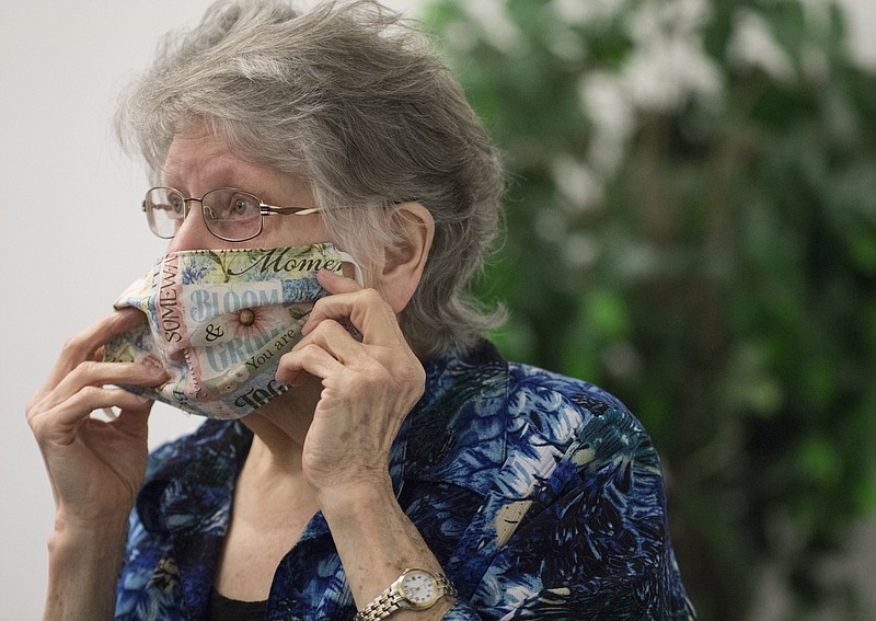 Staff photo by Troy Stolt/ Churchgoer Betty Walker adjusts her protective mask during a church service at the Middle Valley Church of God on Sunday, April 26, 2020 in Hixson, Tenn. Experts say a high number of asymptomatic cases of COVID-19 cases means people should wear masks to avoid unknowing spread of the virus.