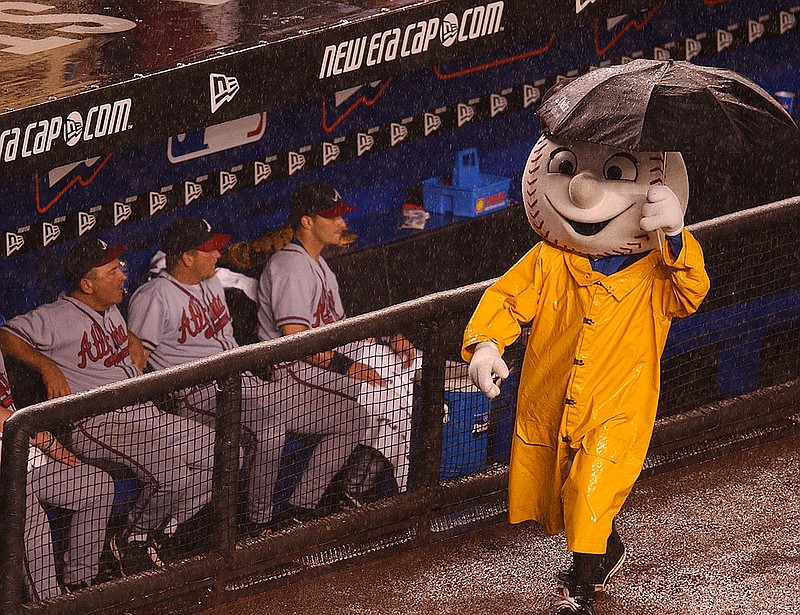 AP photo by Ed Betz / New York Mets mascot Mr. Met walks past the Atlanta Braves' dugout during a rain delay in the fourth inning of the NL East rivals' matchup on June 27, 2002, at Shea Stadium in New York.