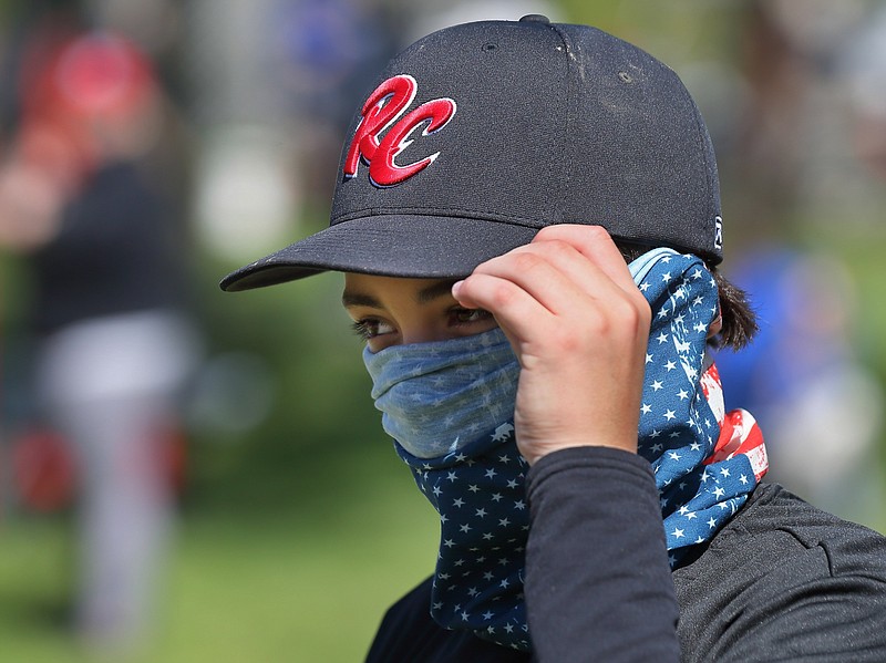 AP photo by David Carson / St. Louis RiverCats youth baseball player Carter Herrin, 13, from House Springs, wears a face covering during the Mother's Day Classic baseball tournament organized by GameTime Tournaments on May 9 in Cottleville, Mo.