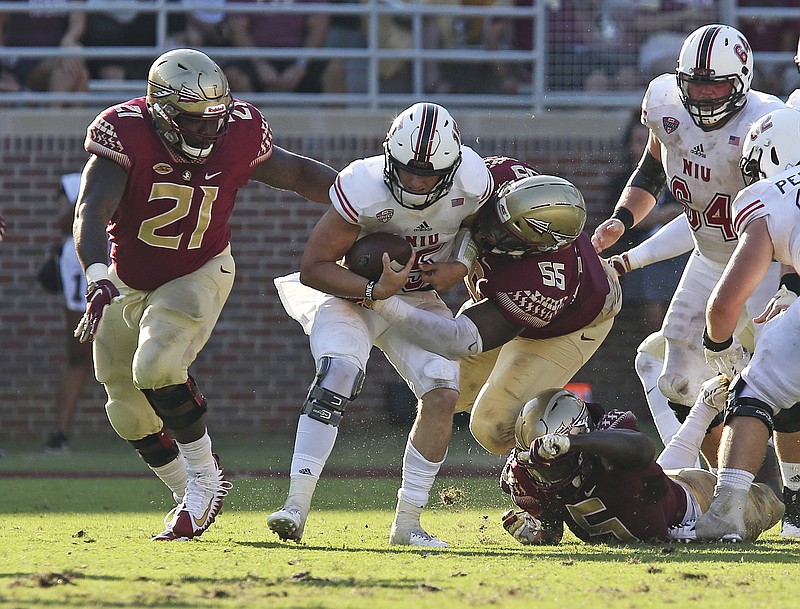 AP photo by Steve Cannon / Northern Illinois quarterback Marcus Childers is sacked by Florida State's Marvin Wilson (21), Fredrick Jones (55) and Dontavious Jackson on Sept. 22, 2018, in Tallahassee, Fla. The road trip to Tallahassee came with a $1.6 million payout to Northern Illiniois, a common arrangement for lower-level programs in games that are generally lopsided mismatches but fill out schedules.