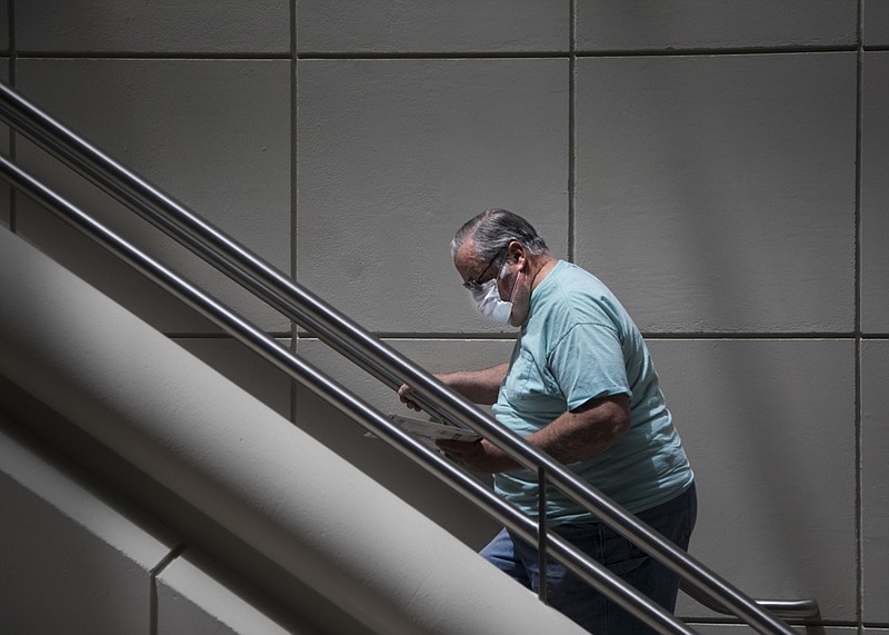 Staff photo by Troy Stolt / Jim Harrison walks up the stairs to the second floor of the Hamilton County Courts building on Monday, May 18, 2020 in Chattanooga, Tenn. Hamilton County has begun to ease restrictions for in-person hearings after being shut down for two months because of coronavirus.