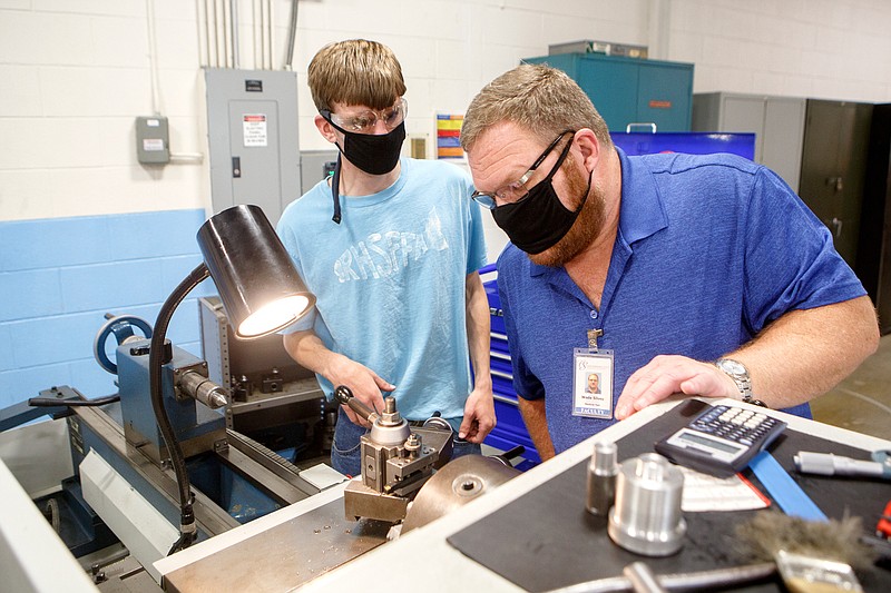 Staff photo by C.B. Schmelter / Machine Tool Technology Senior Instructor Wade Silvey, right, helps Jacob Roerdink in the Machine Tool Lab in the TCAT 2 Building on the campus of Chattanooga State Community College on Tuesday, May 19, 2020 in Chattanooga, Tenn. While most classes at the college have continued online, a few classes began instruction on campus on Monday.